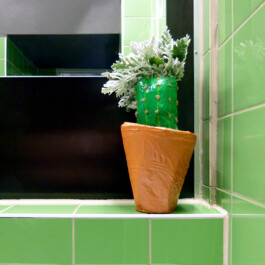 Kleine Skulptur, die aussieht wie ein Kaktus im Blumentopf. 