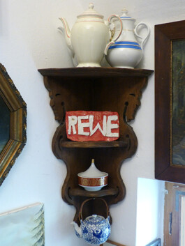 Rewe-Schild aus Ton.