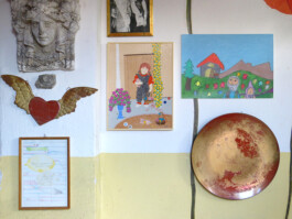 Verschiedene Objekte, Zeichnungen und Gemälde, die an einer Wand aufgehängt sind.