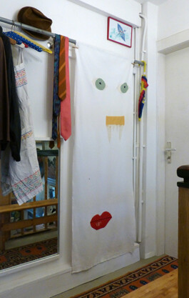 Kunstwerk aus Stoff, darauf sind zwei Augen, eine Nase und ein Mund gestickt.