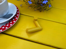 Abstraktes gelbes Objekt auf einem gelben Gartentisch