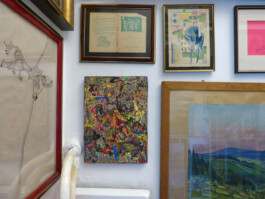 Abstraktes Kunstwerk zwischen anderen Gemälden und Grafiken.