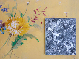 Abstraktes schwarz-weiß Gemälde auf bemalter Wand mit Blumenmuster.