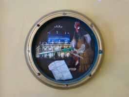 Uhr mit Zeigern und einer Collage auf dem Ziffernblatt.