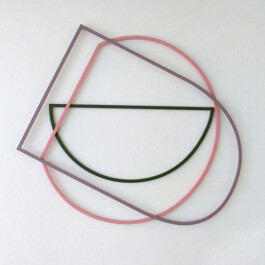 Drei geometrische Metallobjekte sind an einer Wand aufgehängt. 