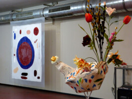 Abstraktes Bild aus Silikon und ein Papmacheobjekt mit Blumen.