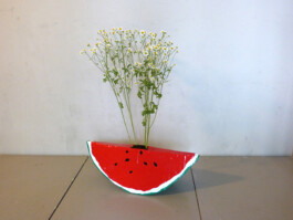 Pappmache-Objekt, dass aussieht wie ein Stück Wassermelone.