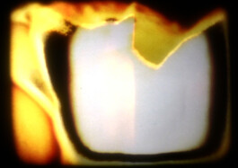 Filmstill eines abstakten Films, gelbe und weiße Form vor schwarzem Hintergrund.