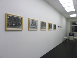 Fotografien und ein Bildschirm im Ausstellungsraum.