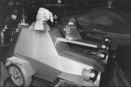 Ein Karousell mit Mini-Panzern, in denen Kinder sitzen.