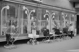 Kinderwägen vor einem Konsum.