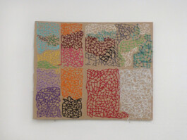 Kunstwerk aus einem Stück Pappe, das mit bunter Wolle bestickt wurde.