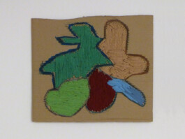 Kunstwerk aus einem Stück Pappe, das mit bunter Wolle bestickt wurde.