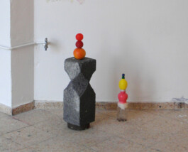 Zwei Skulpturen aus gefundenen farbigen Plastikgegenständen und einem Styroporobjekt.