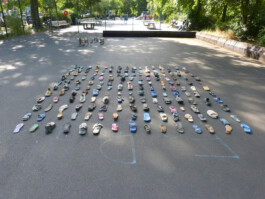 Zwei Kunstwerke, die auf einem Sportplatz präsentiert werden: Eins besteht aus Bauschutt, Metall, Glas und Steinen, das andere aus am Strand gefundenen Schuhen.