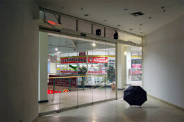 Ausstellungsraum mit einem aufgespannten Regenschirm auf dem Boden.