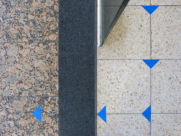 Blaue Markierungen auf dem Boden, die den Weg leiten.