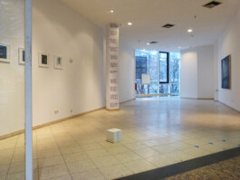 Blick in den Ausstellungsraum mit Papierarbeiten, Objekten und Bildern.