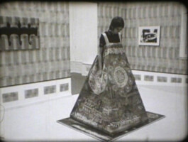 Filmstill von einer Frau in einem Kostüm.