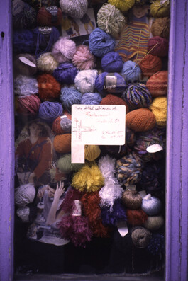 Ein Schaufenster eines Wollgeschäftes, dass mit Wollknäulen vollgestopft ist.