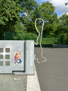 Ein krum gebogenes Metallstück ist an einer Tischtennisplatte befestigt.