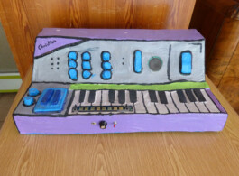 Ein Keyboard aus Pappmache steht auf einem Holztisch.