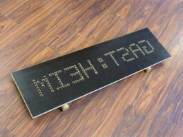 Eine Skulptur steht auf dem Boden im Ausstellungsraum. Sie sieht aus wie ein Skateboard