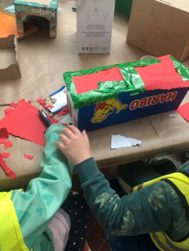 Kinder bauen eine Stadt aus Schachteln und Pappe.