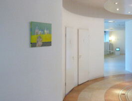 Ausstellungsraum mit einem kleinen Gemälde mit einen Äffchen und Gebäuden.