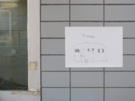 Zeichnung von einem Wohnwagen, die in einer ehemaligen Autowerkstatt hängt.