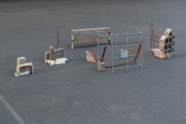 Eine Installation, die eine verkleinerte Version eines Gebäudeensemble darstellt. Sie wurde aus Bauschutt, Steinen, Metalldrähten und Holz gefertigt.