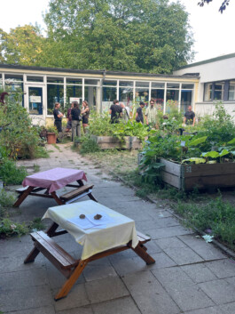 Finissage im Garten mit Menschen, Beeten und Tischen