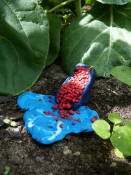Skulptur einer Tomatenrutsche in einem Blumenbeet